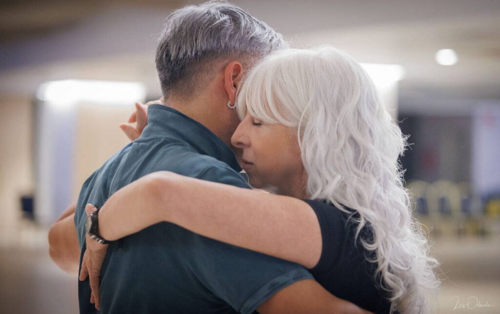 Private tango lesson: a couple in a close embrace, with closed eyes